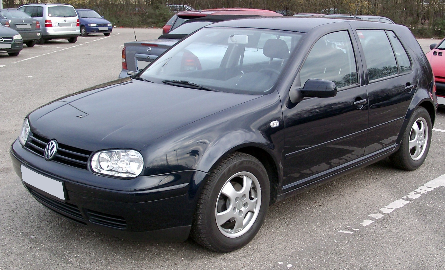 Oudere donkerblauwe hatchback op een parking